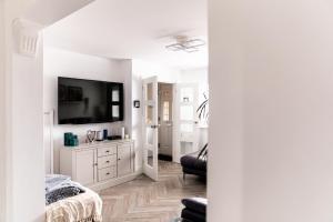 a white living room with a tv and a couch at Inviting 3-Bed House in Manchester in Manchester