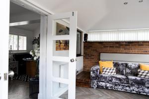 eine Tür, die in ein Wohnzimmer mit einem Sofa führt in der Unterkunft Inviting 3-Bed House in Manchester in Manchester