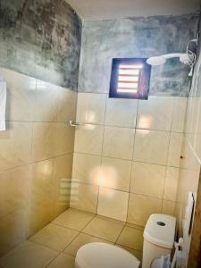 a bathroom with a toilet and a shower with a window at Rooftop Jeri in Jijoca de Jericoacoara