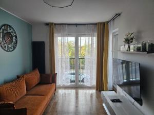 een woonkamer met een bank en een groot raam bij MICHALCZYKA APARTAMENT in Wrocław