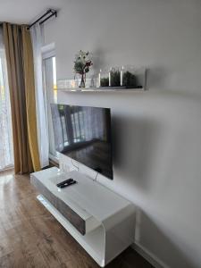 een witte woonkamer met een flatscreen-tv aan de muur bij MICHALCZYKA APARTAMENT in Wrocław +4 foto's