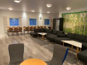 - une salle d'attente avec des canapés, des tables et des chaises dans l'établissement Lomahyppäys, à Naantali