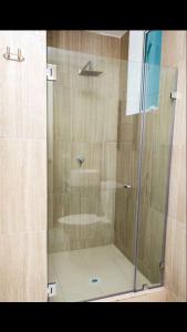 La salle de bains est pourvue d'une douche avec une porte en verre. dans l'établissement 1a, à Panama City