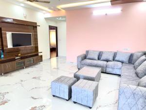 a living room with couches and a flat screen tv at KPHB Phase 15 New Stunning 3 BHK - 5th Floor with Private Parking in Hyderabad