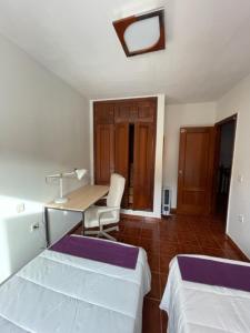 a room with two beds and a desk and a table at Lourdes 1 casa compartida solo con la anfitriona in Breña Baja +38 photos