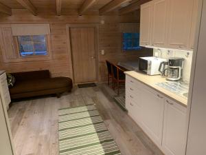 uma cozinha com armários brancos e uma bancada em Lomahyppäys em Naantali