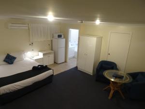 
a room with a bed and a table at Chinderah Motel in Chinderah
