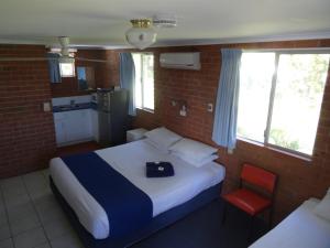 
a bedroom with a bed and a window at Chinderah Motel in Chinderah
