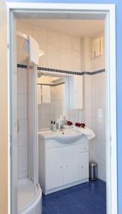 a white bathroom with a sink and a shower at Wohlfühlwelt Riegler in Allentsteig