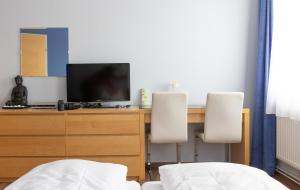 a bedroom with a desk with a television and two chairs at Wohlfühlwelt Riegler in Allentsteig