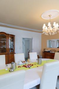 a dining room table with white chairs and a chandelier at Wohlfühlwelt Riegler in Allentsteig