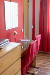 einen Schreibtisch mit roten Wänden und einen Tisch mit roten Stühlen in der Unterkunft Wohlfühlwelt Riegler in Allentsteig