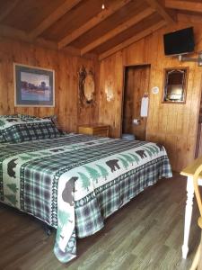 a bedroom with a bed in a wooden cabin at Stampede RV B&B in Tombstone