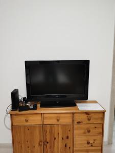 a television on top of a wooden dresser at OASIS APARTMAN II. in Szeged