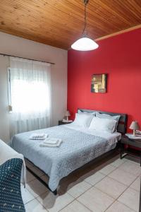 a bedroom with a red wall and a large bed at Cottage Lina in Edessa