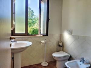 a bathroom with a sink and a toilet and a window at Agriturismo la Casa del Vecchio Mulino in Carassai +49 photos