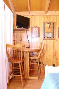 a room with a desk with two chairs and a tv at Stampede RV B&B in Tombstone