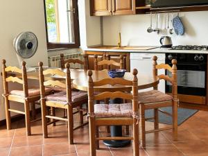 uma cozinha com uma mesa de madeira e cadeiras em Incanto em Nesso