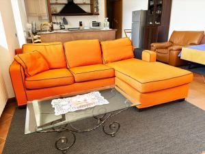 um sofá laranja e uma mesa numa sala de estar em Incanto em Nesso