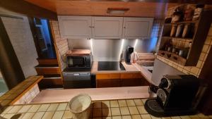 una piccola cucina con armadietti bianchi e forno a microonde di Logement vue sur la seine a Boulogne-Billancourt