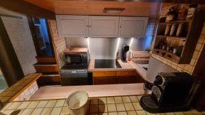 a small kitchen with white cabinets and a microwave at Logement vue sur la seine in Boulogne-Billancourt