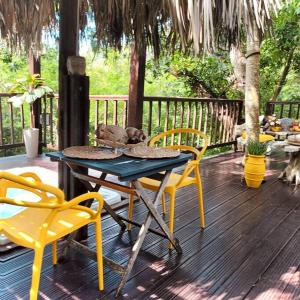 a patio with a table and chairs on a deck at Cabane Charme & Jacuzzi in La Plaine