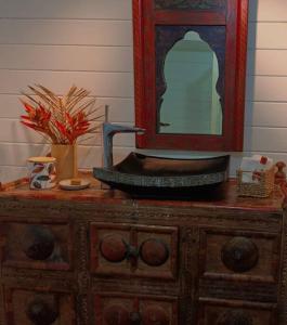 a wooden dresser with a mirror on top of it at Cabane Charme & Jacuzzi in La Plaine