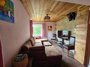 ein Wohnzimmer mit einem Sofa und einem TV in der Unterkunft La BREZOUNIÉRE 2 in Risoul