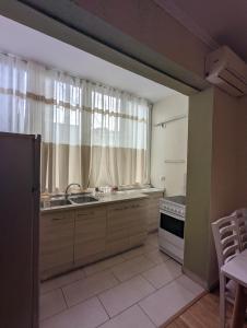 eine Küche mit einem Waschbecken und einem Fenster in der Unterkunft Scanderbeg Square Apartment in Tirana