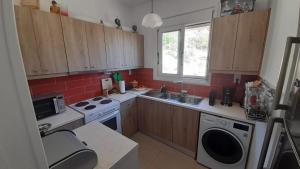 a kitchen with a sink and a stove top oven at Beachfront Oleanders House in Skala in Skala Kefalonias