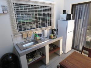 a small kitchen with a sink and a refrigerator at Parksig Self Catering in Musina