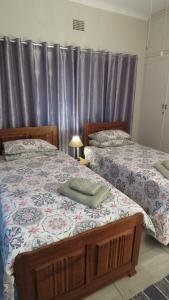 twee bedden naast elkaar in een slaapkamer bij Parksig Self Catering in Musina