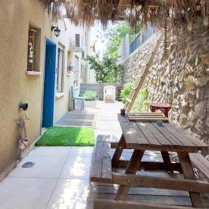 - une table de pique-nique en bois devant un bâtiment dans l'établissement אור בתבור, אירוח בכפר תבור., à Kefar Tavor