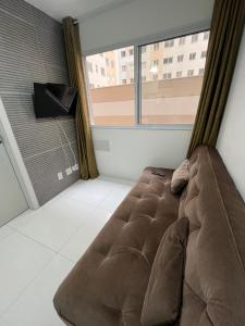 a large brown couch in a room with a window at Apartamento Barra Funda - 202 in Sao Paulo