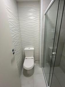 a bathroom with a toilet and a glass shower at Apartamento Barra Funda - 202 in Sao Paulo