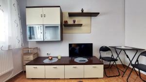 a living room with a tv and a table and chairs at Cristina's place Arad in Arad