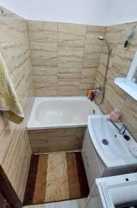 a bathroom with a white tub and a sink at Cristina's place Arad in Arad +2 photos