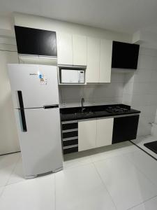 a white kitchen with a refrigerator and a microwave at Apartamento Barra Funda - 202 in Sao Paulo