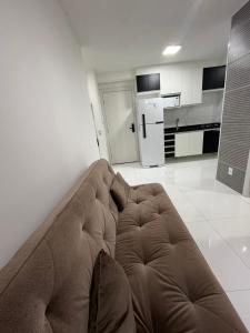 a brown couch in a living room with a kitchen at Apartamento Barra Funda - 202 in Sao Paulo