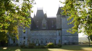 un viejo castillo con árboles delante de él en Les Pinsons, en Montigny-le-Gannelon