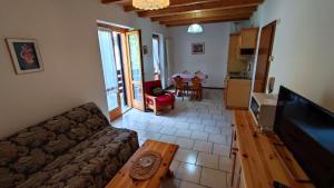 ein Wohnzimmer mit einem Sofa und einem Tisch in der Unterkunft Appartamenti Vacanze Lagolo in Lagolo di Calavino