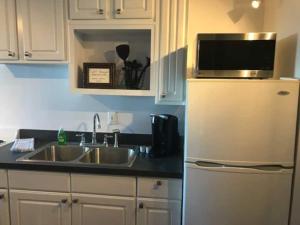 a kitchen with a sink and a refrigerator with a microwave at Beaches are Open-St Augustine in Saint Augustine