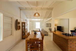 una cucina e un soggiorno con tavolo e sedie di Ilhabela Studios a Ilhabela