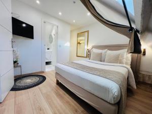 Superbe appartement avec jardin et parking privé في Ris-Orangis: غرفة نوم بسرير كبير وتلفزيون