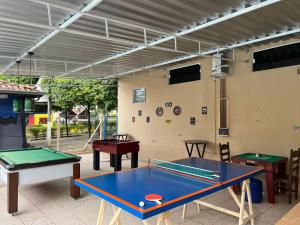 a patio with two ping pong tables and awning at Ananda pousada chalé in São Pedro