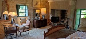 a bedroom with a bed and a table and a tv at La Coudonie in Sarrazac