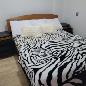 uma cama com estampa de zebra com duas almofadas em Apartamento Deluxe Isla Margarita - Costa Azul em Porlamar