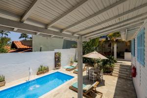 a patio with a swimming pool and a pergola at Ilhabela Studios in Ilhabela