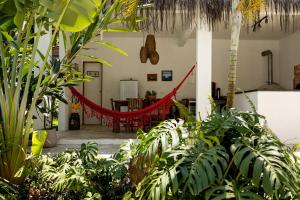 una stanza con amaca rossa al centro delle piante di Ilhabela Studios a Ilhabela