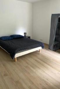 a bed in a room with a wooden floor at Appartement centre ville in Châteauroux
